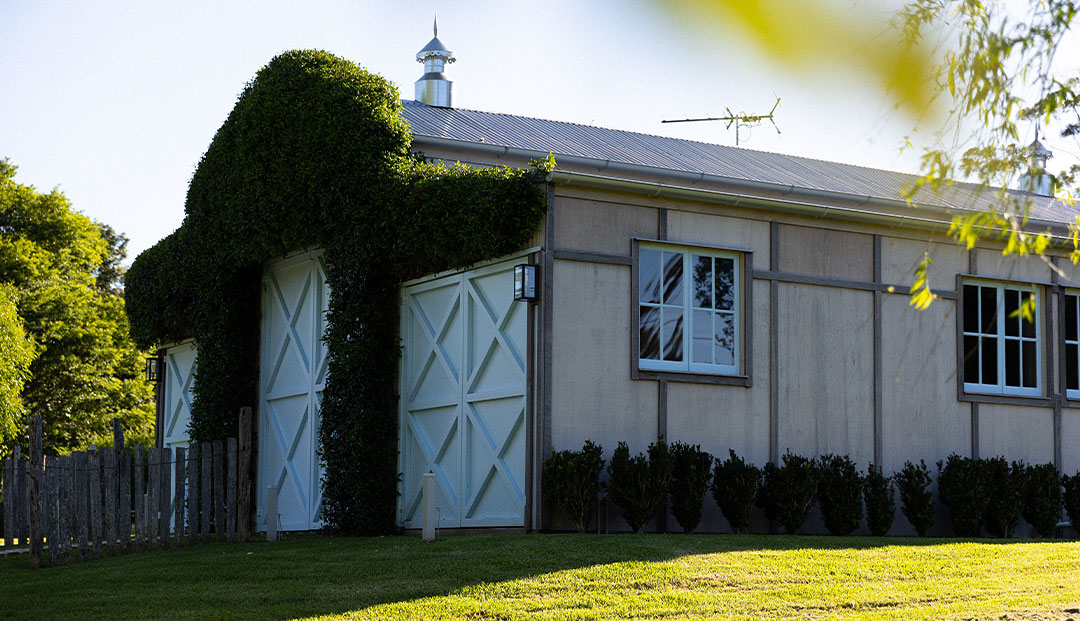 Vine-clad barn with chic outdoor lantern.