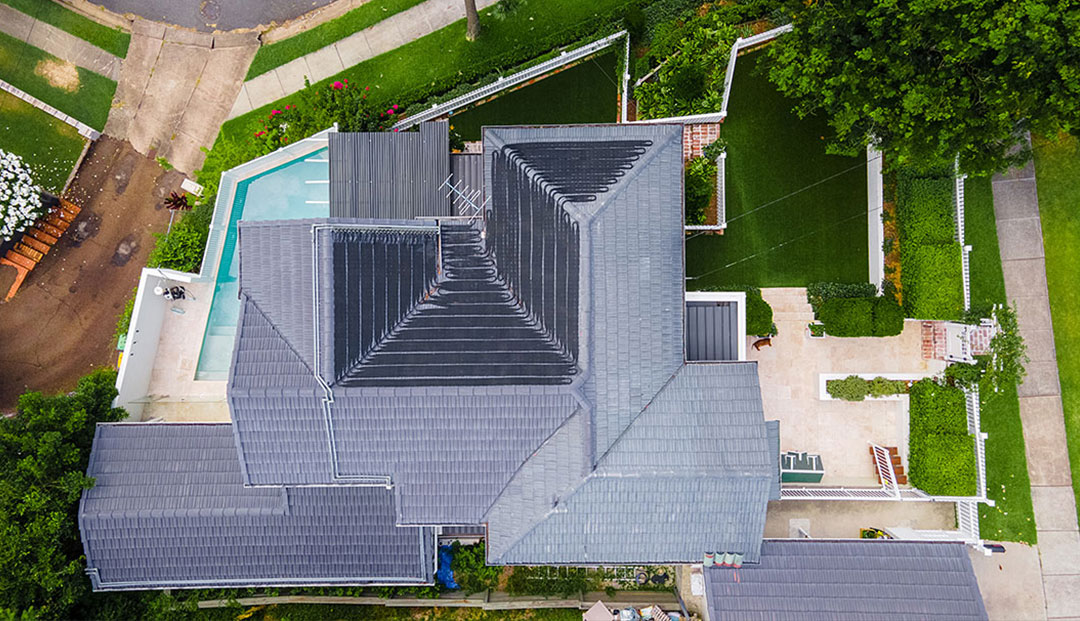 Brisbanes Aerial view of a large home with a pool and manicured yard.