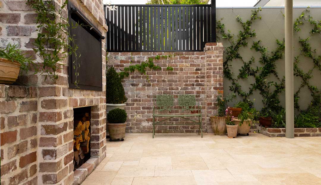 Patio with brick walls, greenery, and a bench at Hazelmere Parade, Brisbane.