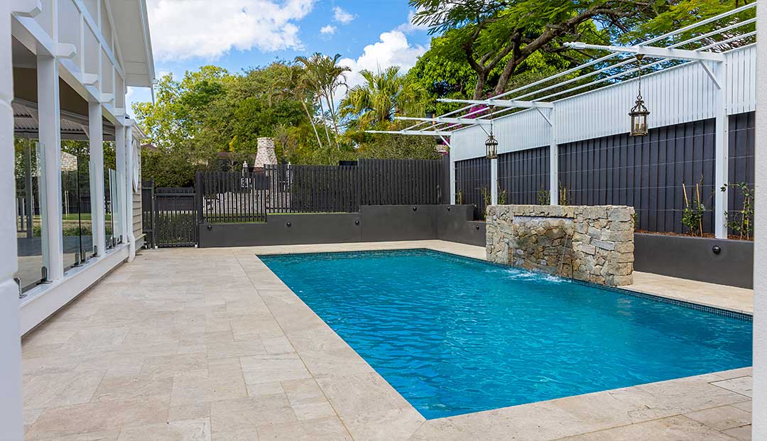 Swimming pool with stone waterfall and pergola at Hipwood Street, Brisbane.